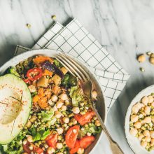 Vegan lunch bowl. Flat-lay of dinner with avocado, grains, beans, sprouts, greens and vegetables over marble background, top view, copy space, square crop. Clean eating, vegetarian, diet food concept