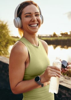 Happy sportswoman taking a water break outdoors